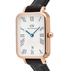 Close-up of the Daniel Wellington Quadro Roman Numerals watch, featuring a rose gold case, white dial with a guillochÃ© pattern, blue hands, and a black leather strap.