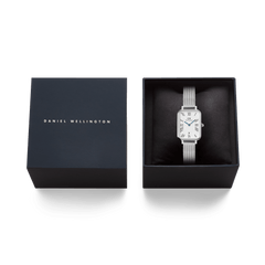 Daniel Wellington Quadro Sterling Roman Numerals Date watch in its presentation box, showing the rectangular white dial and silver mesh strap.