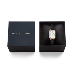 Daniel Wellington Quadro Roman Numerals Date watch in rose gold with a white dial and black Sheffield leather strap, presented in its official black box.