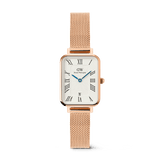 Daniel Wellington Quadro Melrose women's watch with a rectangular white dial, Roman numerals, a date window, and a rose gold mesh strap.