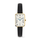 Daniel Wellington Quadro Roman Numerals Date Sheffield Gold women's watch with a rectangular gold case, white dial featuring Roman numerals and a date window, and a black leather strap.